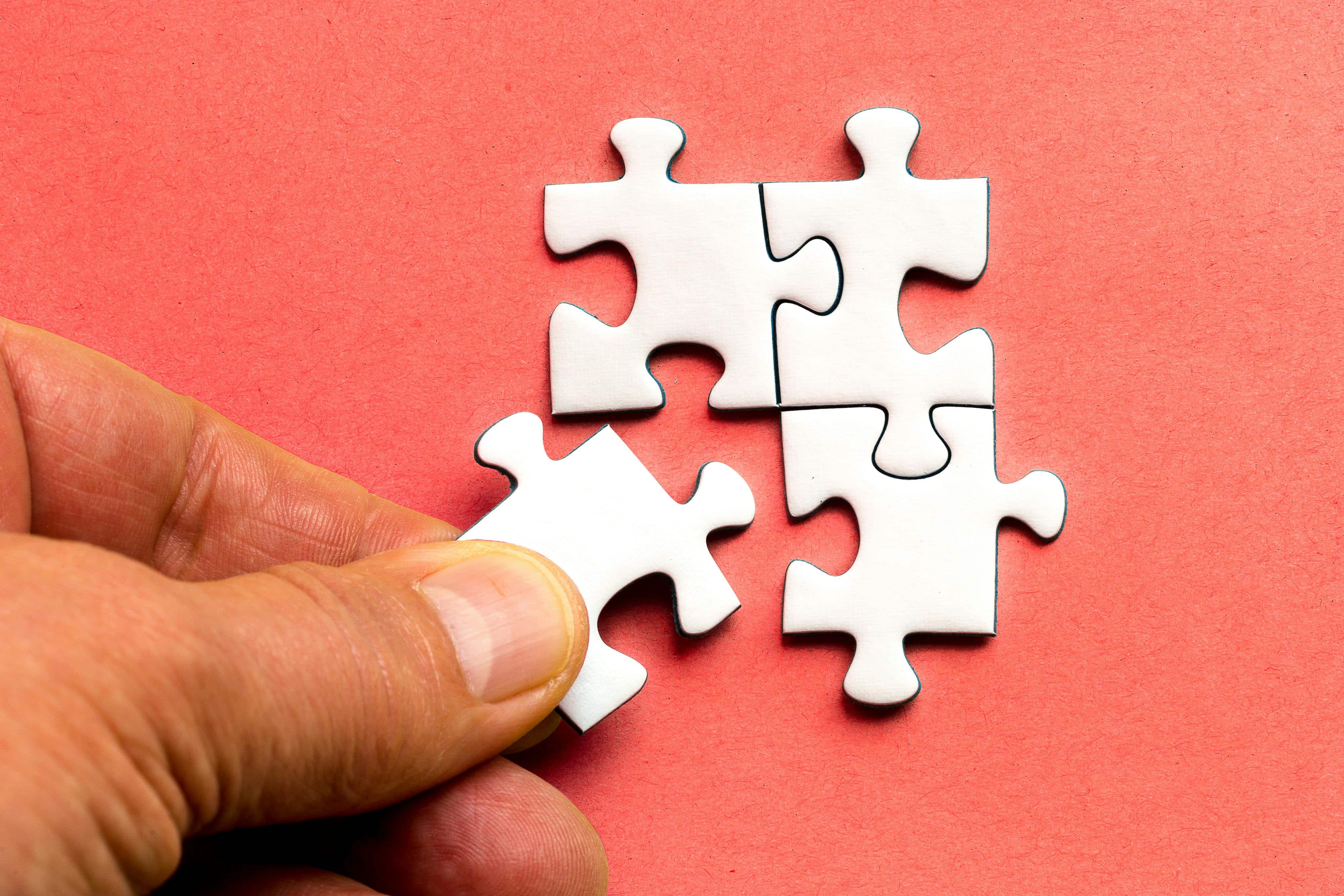 image of two hands putting two pieces of jigsaw together heading EM Law article on merger and acquisition law