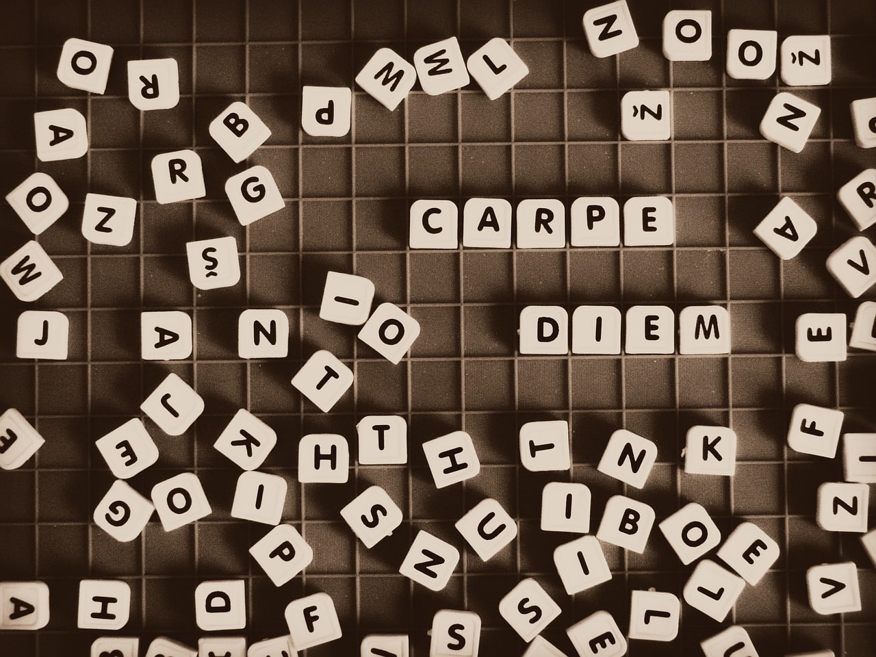 Carpe diem word created from Scrabble pieces heading an article by EM Law about latin words, their use in law and their meanings in
