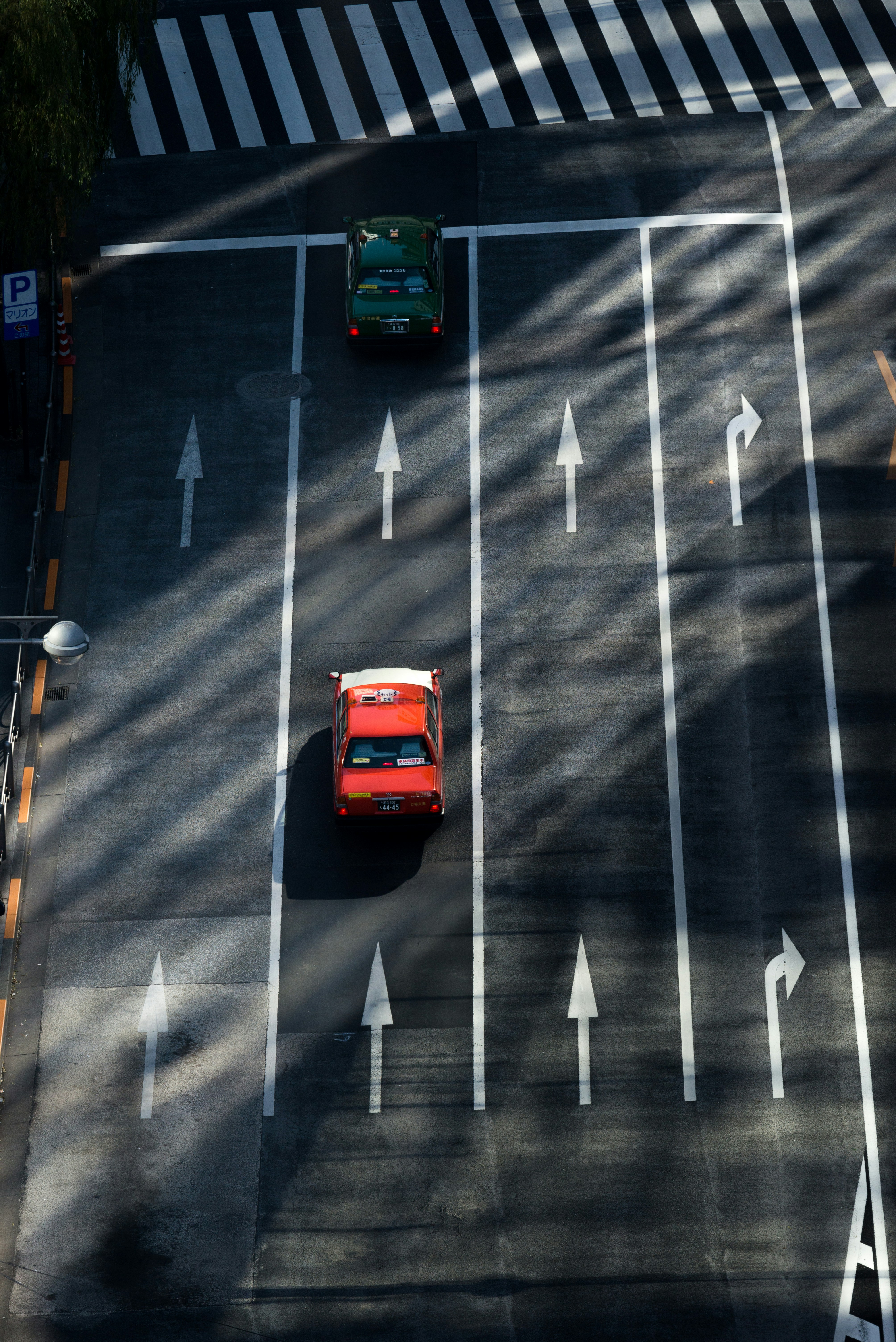 an image of a red car heading towards a direction of an arrow on the highway