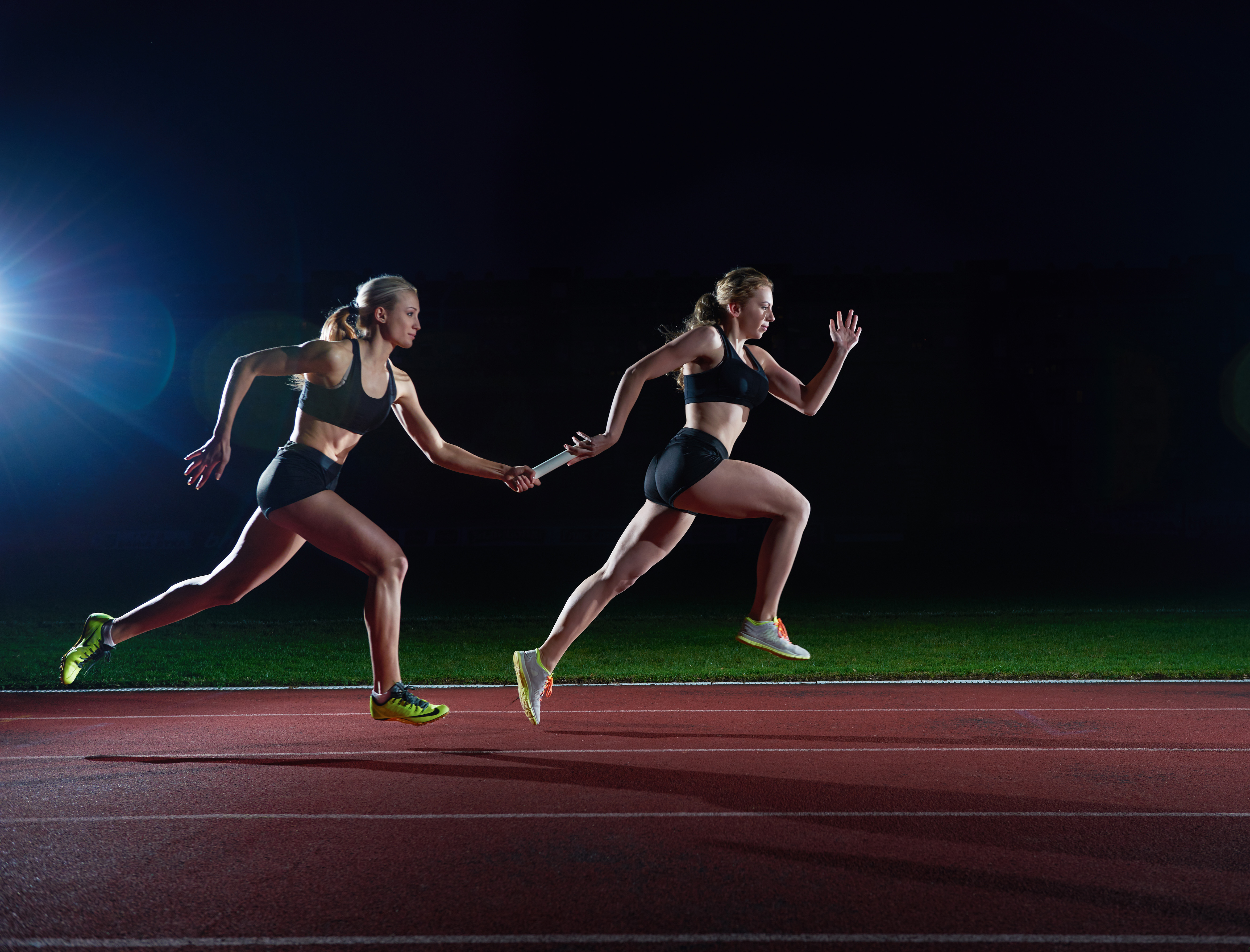 Woman athletic runners passing baton in relay race heading an article by EM Law about Novation (photo by vecteezy)