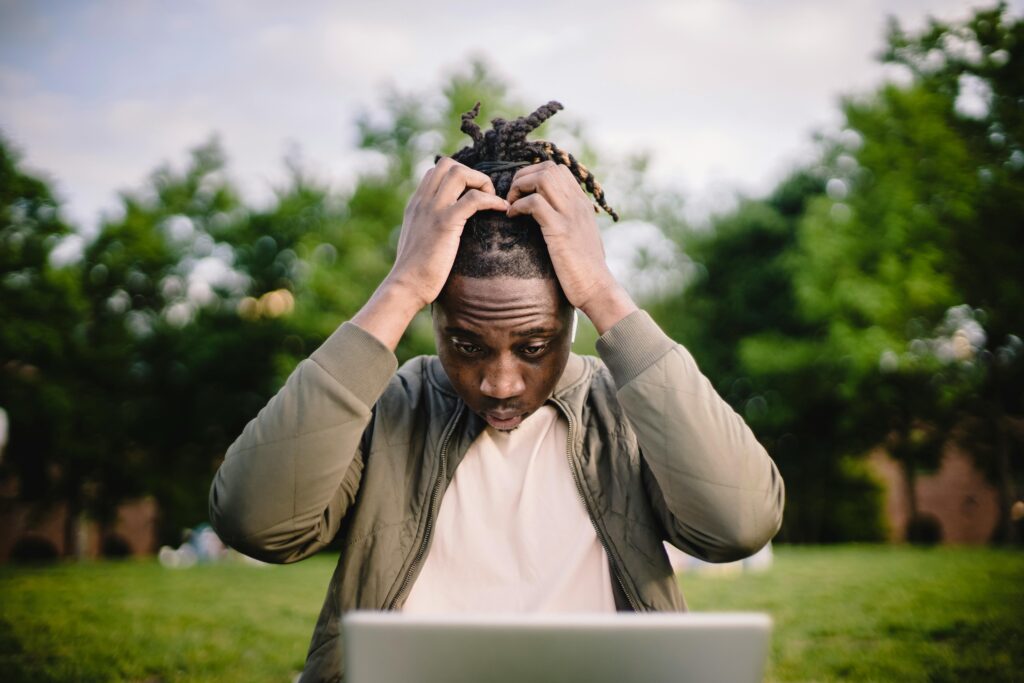  image of a man holding his head over computer inside an article by EM Law about Negligence