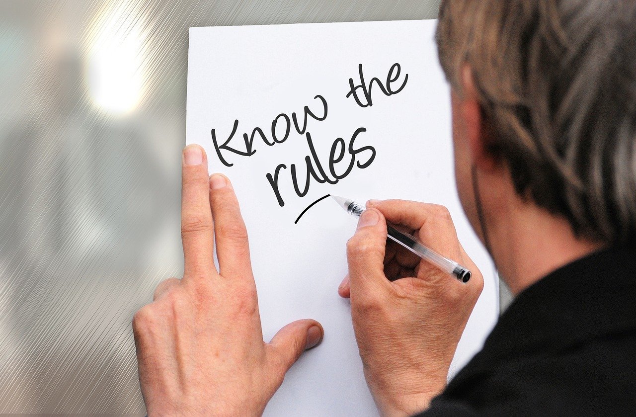 image showing a man writing 'know the rules' on pice of paper heading can article by EM Law about sexual harassment