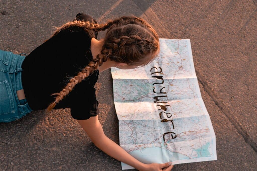 Image of a girl holding a map with 'anywhere' written on it inside an article by EM Law about traps for tenants