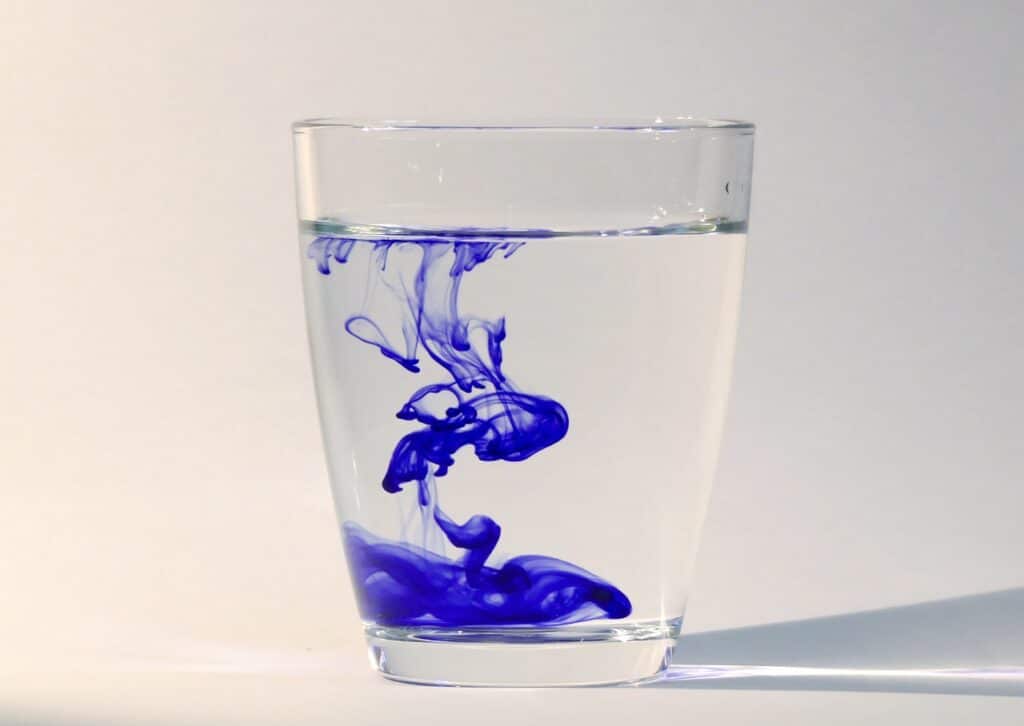 image of blue ink spilled in a glass of waterl inside an article by EM Law about wet signature in law