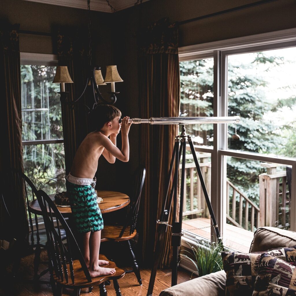 a small boy looking through a telescope