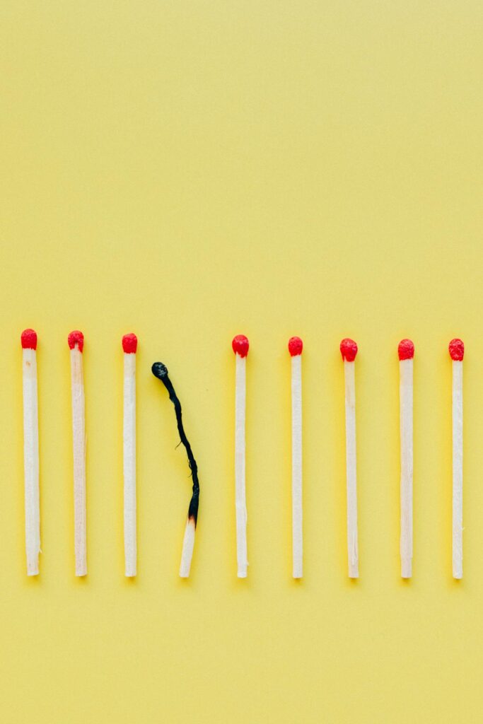 a row of matches with one burned