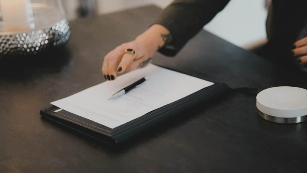 image of a hand signing a document