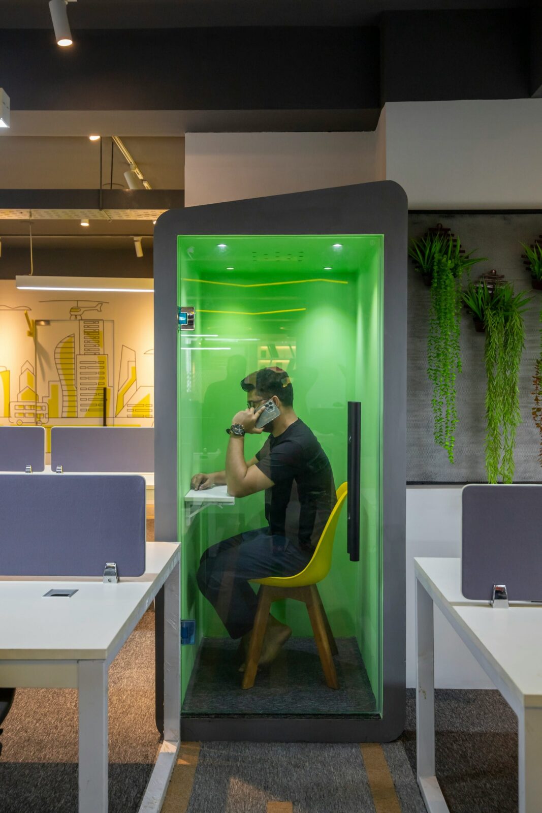 image of a man sitting in a noise proof booth making a call