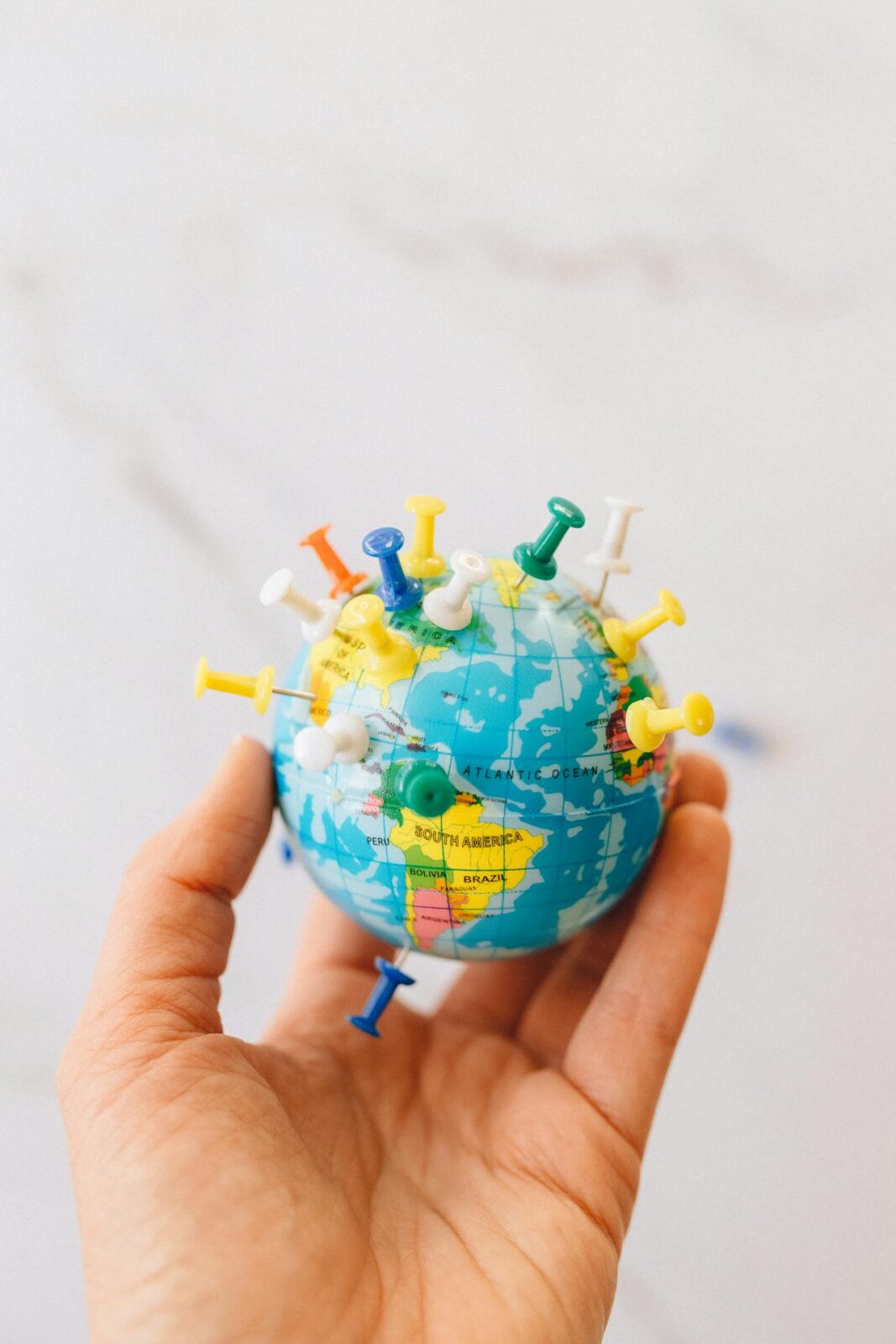 image of a globe with pins stuck in it