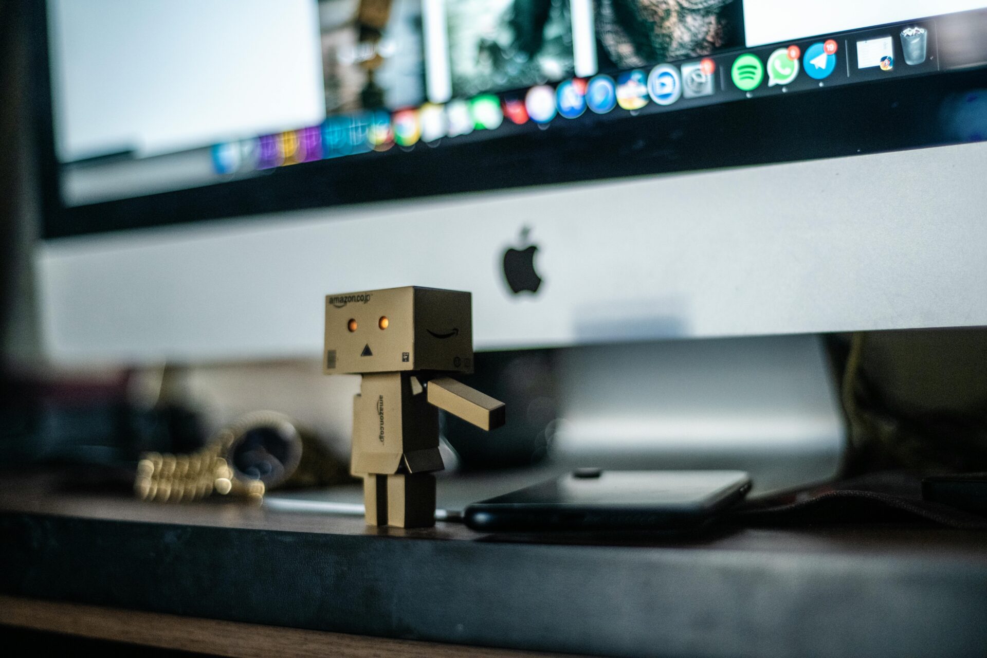 Miniature AI robot next to computer online in an EM Law blog on the legality of personal data scraping to train AI models
