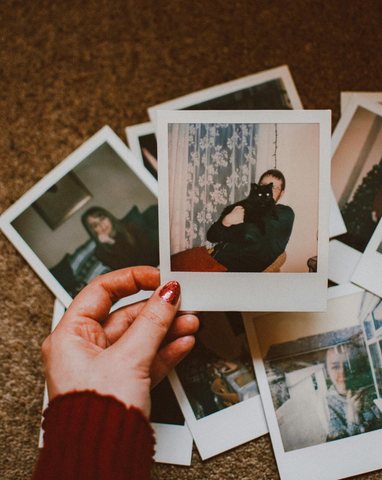 image of a individual holding a Polaroid picture of a man with a black cat in further reading section on EM Law blog on UK AI strategy