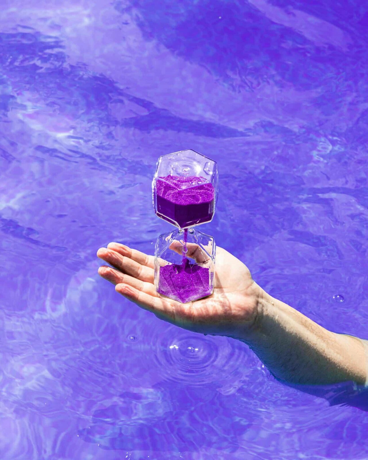 Purple hourglass in hand EM Law