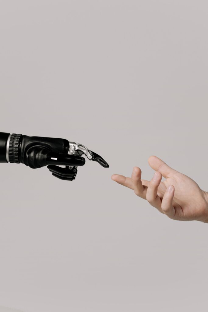 an image of human and robot hands nearly touching in an EM Law blog about legal AI