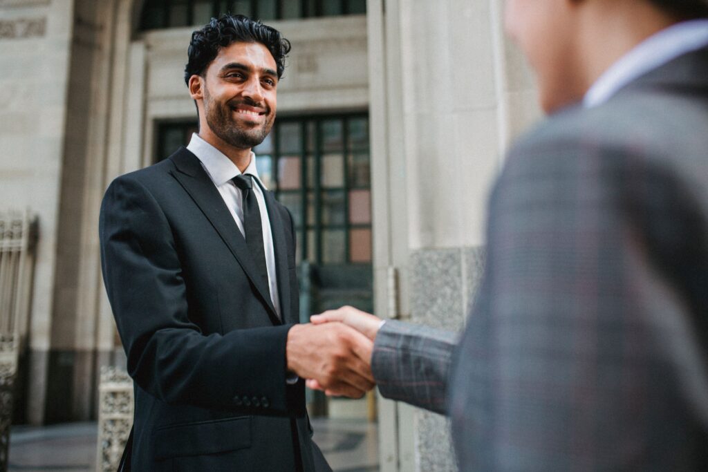 image of parties happy and shaking hands after doing deal to buy company in EM Law blog about SPA